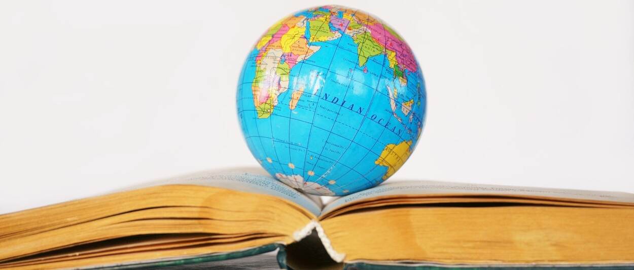 kleine globe ligt op een opengeslagen boek